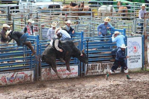 Blake Blanchard of Pearland, TX, manages to stay on his bull as everyone runs to safety during the International Finals Youth Rodeo on the morning of July 11. Countywide &amp; Sun/Natasha Dunagan