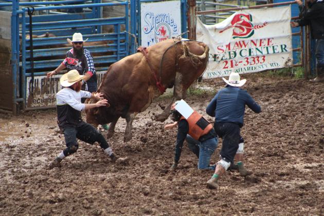 Rodeo volunteers scramble to protect Ryker Butler of McLoud from a bull after his ride at the IFYR on the morning of July 11. Countywide &amp; Sun/Natasha Dunagan