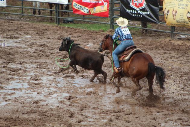 Kasey Keys of Shawnee doesn't give up on roping his steer, while riding through deep mud.
