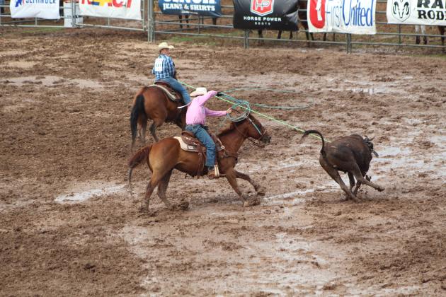 Kasey Keys, left, of Shawnee ropes a steer and holds him for Rance Tucker of Blair, OK, to rope the back legs during the Team Roping event of the IFYR on the morning of July 11.