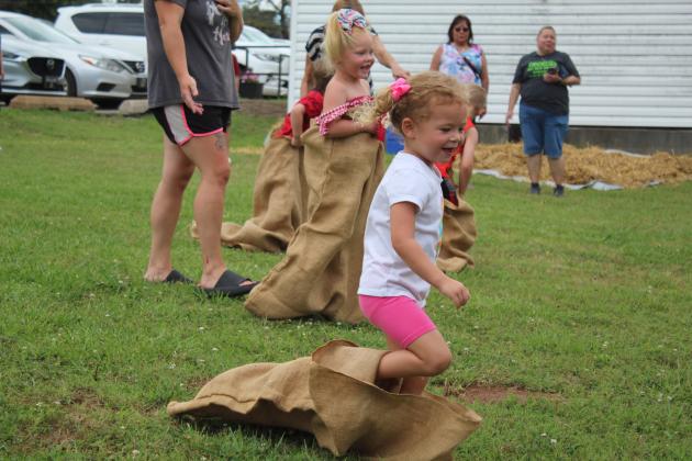 Oakley Adams, 3, of Moore, runs out of her sack at the end of the sack race for ages 0-4 years during the McLoud Blackberry Festival on July 8. The Kiwanis Club also sponsored turtle races, balloon toss, money in the hay, and a duck pond for kids. This is their second year to do so. Countywide &amp; Sun/Natasha Dunagan