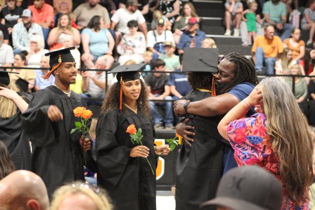 Maud High School graduates Vcake Wassana-Street, Reese Street and Braxton Street present roses and share a moment with their parents Royce and Brook Street during the Commencement Ceremony on May 12. Countywide &amp; Sun/Natasha Dunagan