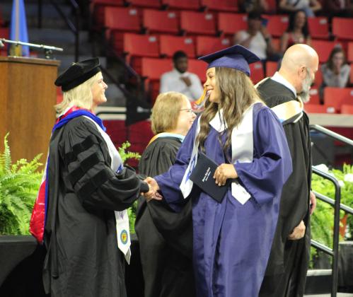 Shawnee graduate Anneca Anderson shakes hands with then-Superintendent Dr. April Grace at graduation on May 18. Ceremonies were held at Lloyd Noble Center in Norman due to tornado damage at Shawnee High School.