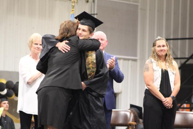 Maud Graduation - Graduate Eli Bunnell gets a hug from Superintendent Cindy White.
