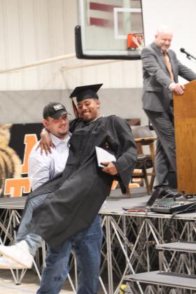 Maud junior Korbyn Finch helps graduate Vcake Wassana-Street from the stage.
