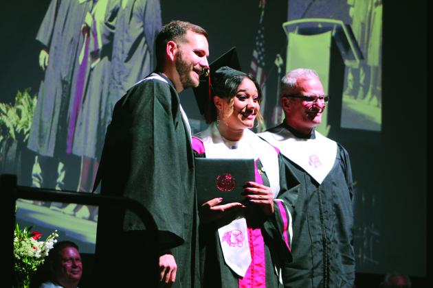 North Rock Creek graduate Symphony Green poses with her diploma and NRC Principals Justin MacDonald and Chad Brooking during graduation on May 19 at the NRCHS gym.