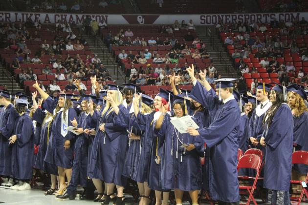 The Shawnee Class of 2023 holds up wolf signs as "Hail, Shawnee High School" is sung by members of the SHS Choir at graduation on May 18. Countywide &amp; Sun/Natasha Dunagan