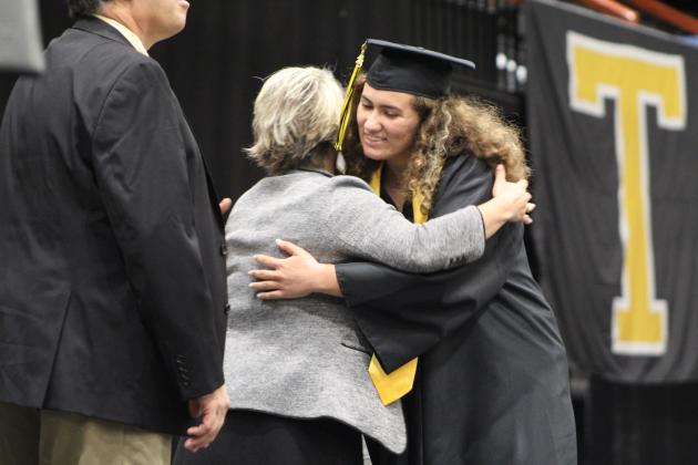 Tecumseh Assistant Superintendent Brandi Burks gets a hug from graduate Lexi Horn at graduation on May 17. Countywide &amp; Sun/Natasha Dunagan