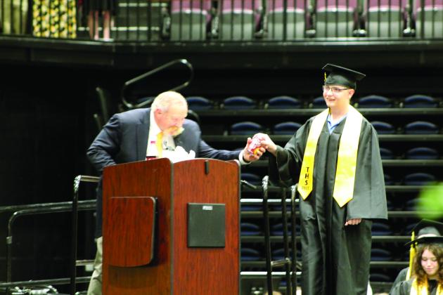 Tecumseh High School Principal Randy Dilbeck gets a can of Dr. Pepper from graduate Tallon Formanski, as he did from all of the 143 graduates, at graduation on May 17. Countywide &amp; Sun/Natasha Dunagan