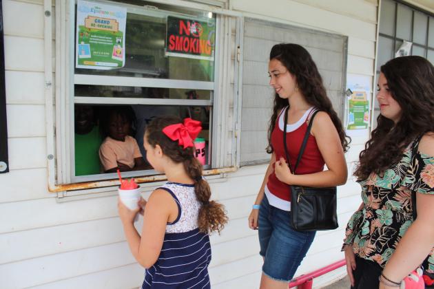 Tarryn Henry hands a snow cone to Sarah Jett, 8, as Raquel Jett, 18, and Esther Jett, 14, wait.
