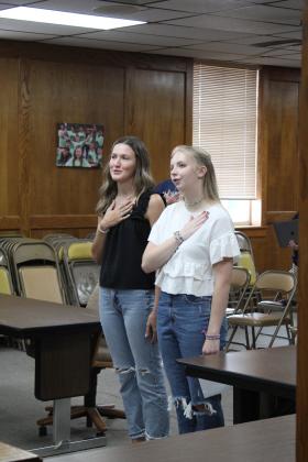 Shawnee High School seniors Kennedy Santos and Marilyn Bartley say the Flag Salute, after Bartley led the invocation at the Aug. 7 Shawnee Board of Education meeting. Countywide &amp; Sun/Natasha Dunagan