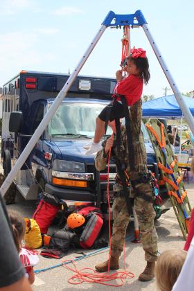 Kaianna Gonzales-Wesley, 3, of McLoud, gets a ride in a harness and pulley operated by Ron Poland, with the U.S. Army National Guard, at Cops N' Kids, Aug. 26. This was a popular new attraction at the event. Countywide &amp; Sun/Natasha Dunagan
