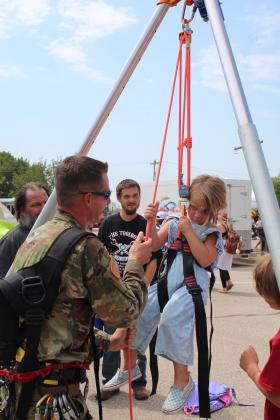 A shy Brooklyn Cagle, 3, of Shawnee, is reluctant when Ron Poland, with the U.S. Army National Guard, offers her the rope that controls her harness and pulley ride at Cops N' Kids, Aug. 26. Of course, Poland never let go of the rope. This was a popular new attraction at the event. Countywide &amp; Sun/Natasha Dunagan