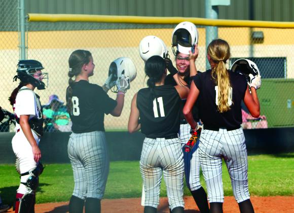Tecumseh senior Serenity Jacoway hits helmets with her teammates after making a home run in the second inning of the Aug. 22 game with Holland Hall. Countywide &amp; Sun/Natasha Dunagan