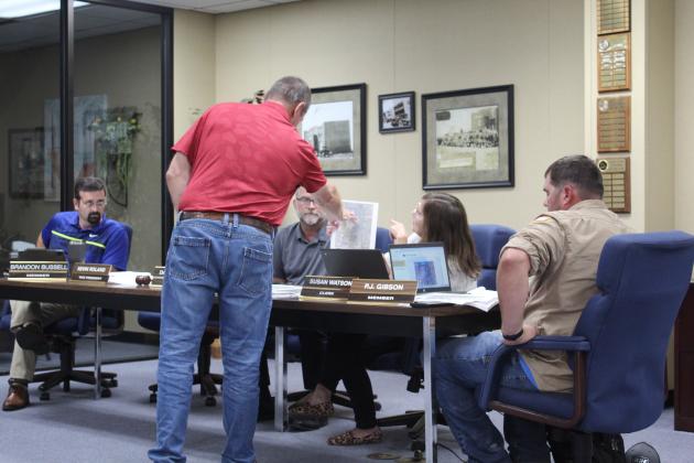 Engineer Wayne Barker with Barker and Associates, Inc., explains a map regarding one option for the lagoon remediation project to Bethel Board of Education Clerk Susan Watson and the other board members on Aug. 14. Also shown, from left, are Brandon Bussell, Board President David Elmore and P.J. Gibson. Countywide &amp; Sun/Natasha Dunagan