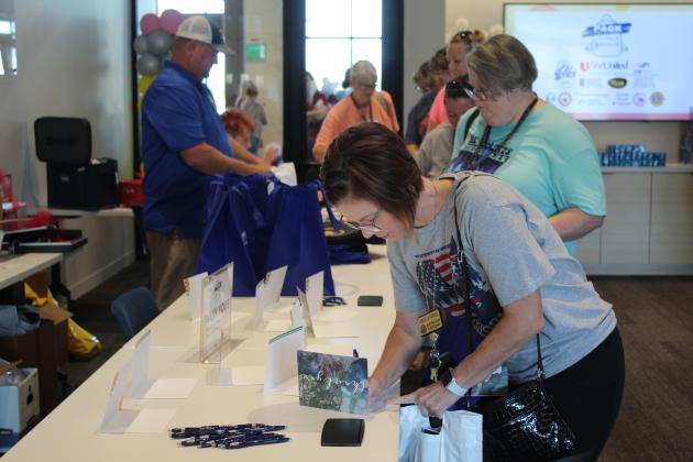 North Rock Creek High School science teacher Becki Powell fills out a thank-you note for the sponsors at the Second Annual Pack the School Teacher Supply Stop event on Aug. 1 at the First United Bank on Harrison. Behind her is Lacie Blakemore, a third grade teacher at Liberty. There were 12 sponsors who made the event possible. Countywide &amp; Sun/Natasha Dunagan
