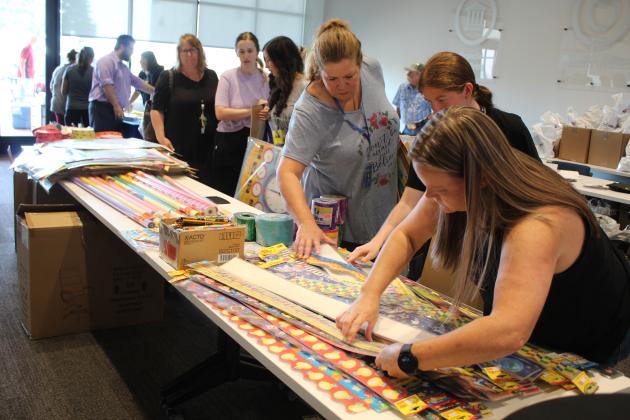 From right, Cross Timbers Elementary fourth-grade teachers Sheena Ramirez and Hannah Carr, and Liberty kindergarten teacher Kaylee Hoffman look through decorative borders during the Second Annual Pack the School Teacher Supply Stop, held at First United Bank's Harrison branch in Shawnee on Aug. 1. Hoffman said she usually spends a lot on supplies, and the event is "definitely helpful." Countywide &amp; Sun/Natasha Dunagan