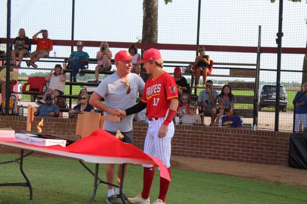 1975 State Champion team member Bud Akins is presented a game ball by senior Dayton Forsythe.