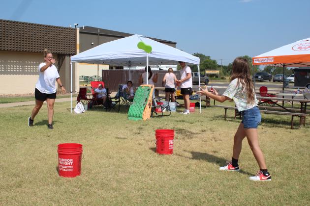 Cheer mom and volunteer Kristin Taron, left, plays Sponge Toss with Dixie Harris, 11, of Yukon, during the Third Annual Tecumseh High School Cheer Booster Club Car Show on Aug. 26. The event also offered a Relay Race with water and a Creeper Race. Countywide &amp; Sun/Natasha Dunagan