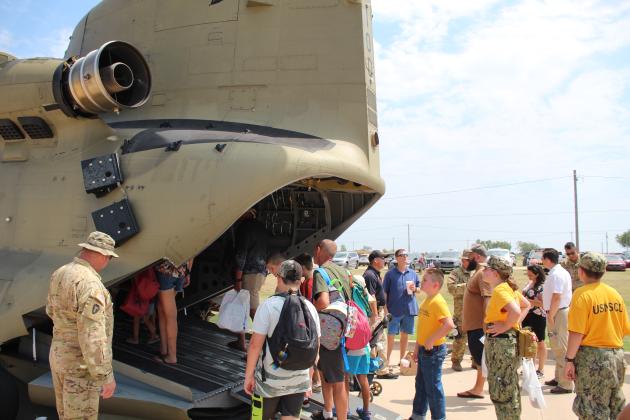 U.S. Army Chief Warrant Officer 5 Mike McGill watches as children and adults, including a few U.S. Naval Sea Cadets, enter the Chinook Cargo Helicopter (CH47) F Model at Cops N' Kids, Aug. 26. This was the first year for the CH47, out of Lexington, OK, to participate in the event, and it was their Mystery Display. Countywide &amp; Sun/Natasha Dunagan