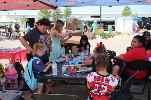 Grant Coordinator Tiffany Rodriguez, far left, watches as several girls make bracelets and necklaces at the Absentee Shawnee Behavioral Health Grant booth during Cops N' Kids on Aug. 26. There were at least 30 organizations and 33 law enforcement agencies that participated in the event this year. Countywide &amp; Sun/Natasha Dunagan