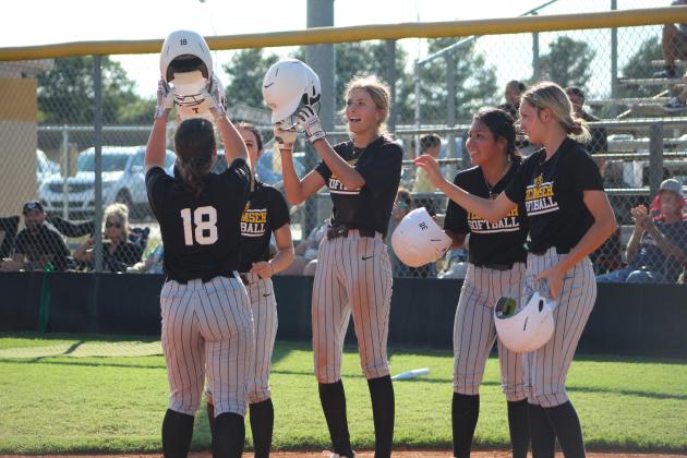 Four Tecumseh Lady Savages hit helmets with junior Katie Overstreet at home plate after she smashed a home run during the home game with Cleveland on Aug. 14. The THS fast pitch team won, 17-0. Countywide &amp; Sun/Natasha Dunagan
