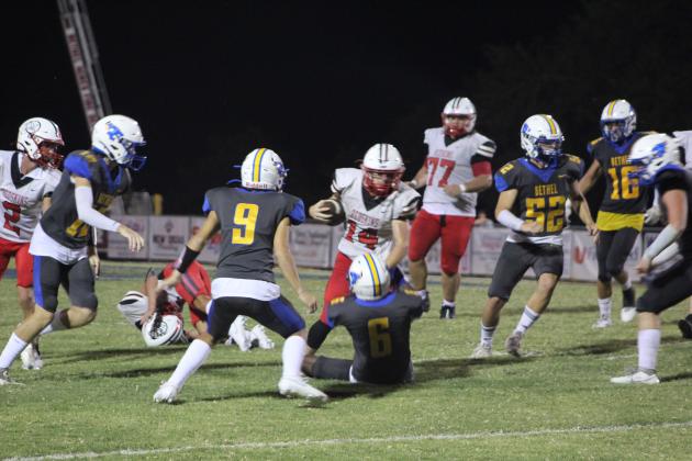 McLoud's Kaiden Cue (#14) runs the ball, as Bethel's Ezra Powis tries to take him down, in the fourth quarter of the Bethel home game on Sept. 8. The Redskins won, 28-21. Countywide &amp; Sun/Natasha Dunagan