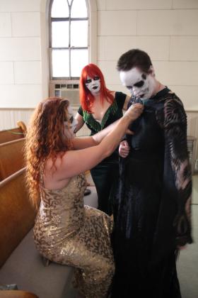 Artemis Epstein helps costume-designer Molly Davis with her dress, as Kinsley Bingham watches, during the filming of the Dead End Film House silent short film, "Seance," at the Broadway Chapel in Tecumseh on Sept. 8. Countywide &amp; Sun/Natasha Dunagan
