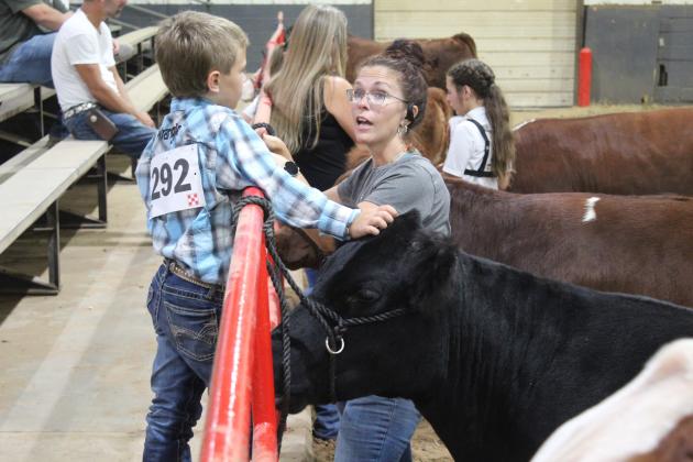 Tonya Turnpaugh talks with Jimmie Spears, 9, both of Tecumseh, as Spears pets his Breed Champion Commercial Heifer during the Beef Show of the Pott. County Free Fair on Sept. 8. Countywide &amp; Sun/Natasha Dunagan