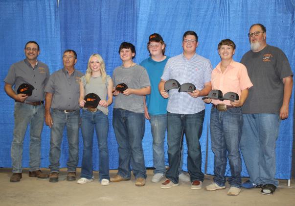 Representatives from the Farmhand Olympics North Rock Creek Teams #1 and #2 accept their Farm Bureau hats for winning first and second in the relay races at the event, held on Sept. 6. Shown, from left are event organizer Josh Grundmann, Pott. Co. Free Fair Board Member Lynn Marlow, Marlee Reece, Logan Matlock, Gibson French, Cooper Kline, Stephen Wickerd and Board Member Tim Underwood. Countywide &amp; Sun/Natasha Dunagan