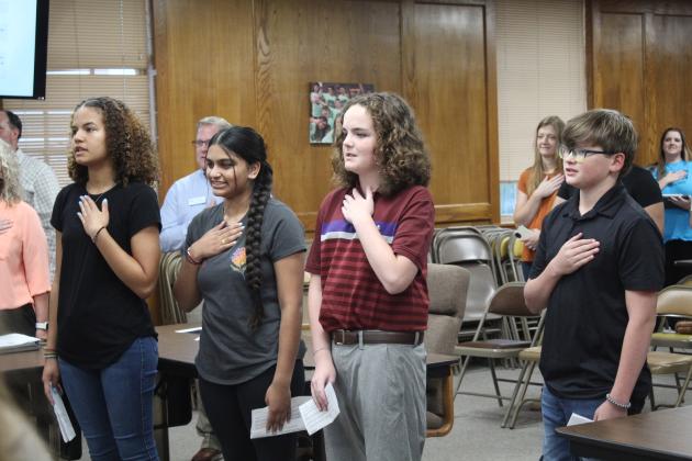 Shawnee Middle School students Khloe Tungate, Alisha Patel, Sammy Thomas and Noah Bass lead the flag salute during the Sept. 11 Shawnee Board of Education Meeting. The students also spoke about the Guided Inquiry Design program. Countywide &amp; Sun/Natasha Dunagan