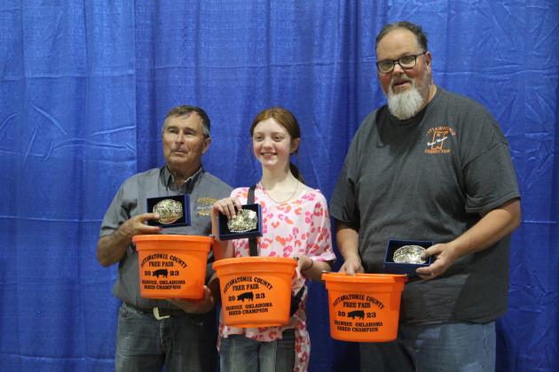 Tatum Smith, of Pottawatomie County 4-H, poses with Pott. Co. Fair Board Members Lynn Marlow and Tim Underwood, as well as her belt buckles and buckets won in the Swine competition on Sept. 9. Smith won the Gold Belt Buckle High Point Award. She also won Grand Champion Market Swine, Reserve Grand Champion Gilt, Market Swine Berkshire and Hampshire and Yorkshire Gilt. Countywide &amp; Sun/Natasha Dunagan