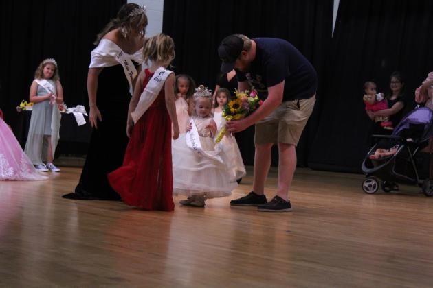 Karsin Glasgow, 2, is offered flowers by her father after being crowned Tiny Miss Frontier Days by 2022 Miss Frontier Days Sadie Boatman and Tot Miss Frontier Days Mae McCullough on Sept. 24 at the W.P. Wood Alumni Center. There were eight contestants in the Tiny division, ages 0-3 years. The Tiny Miss Runner-up was Olivia Hutchison, also 2.