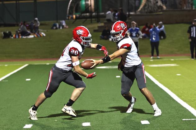 North Rock Creek's Kandon Kelough gives a handoff  to Calvin Bray. Photo courtesy of Gowin Photography