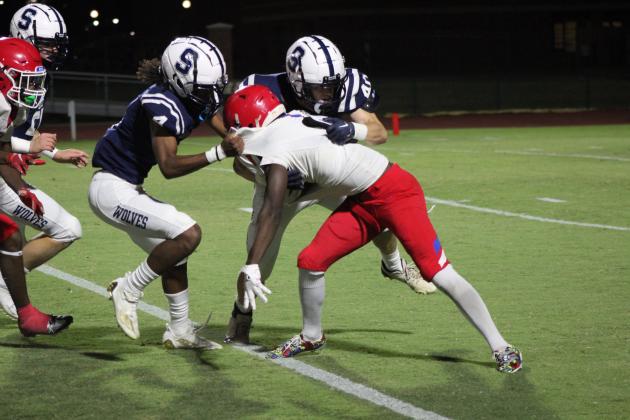 Shawnee junior Keeno Citizen (#4) and senior Jayson Hair (#40) hold back a John Marshall Bear ball carrier during the Homecoming game held at OBU on Oct. 6. The Wolves won, 37-0. Countywide &amp; Sun/Natasha Dunagan