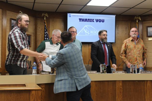 Winston Ayala, of A &amp; S Roofing and Contracting, shakes hands with the board.
