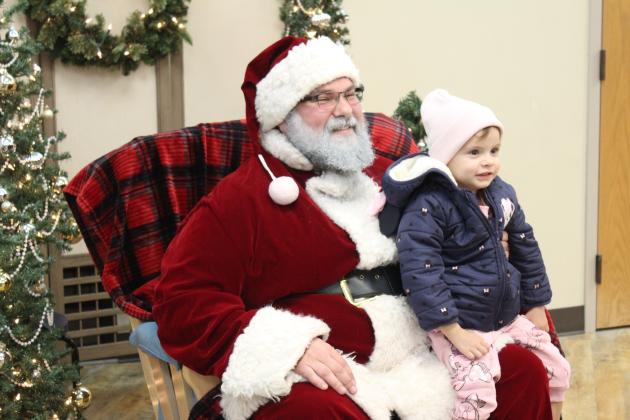 Octavia McIntyre, 2, of Shawnee, sits on Santa's lap in the Shawnee Pioneer Library during the Shawnee Tree Lighting event on Nov. 17. Kids could also decorate ornaments, make gingerbread houses, and create something in the Maker Lab. Countywide &amp; Sun/Natasha Dunagan