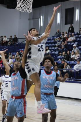 Shawnee junior Isaiah Smith jumps between two Western Heights defenders to make the bucket during the Dec. 12 home game. The Wolves won, 86-58, and the Lady Wolves won, as well, 60-8, earlier that night. The Shawnee basketball teams have returned to playing at the newly-repaired Performing Arts and Athletic Center (PAAC). Countywide &amp; Sun/Natasha Dunagan