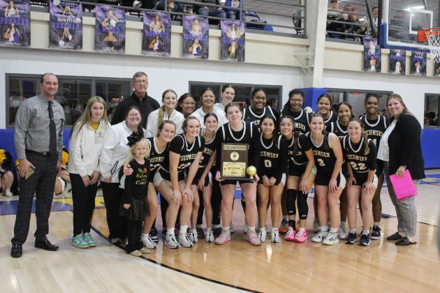 The Tecumseh Lady Savages and their coaches pose with the First United Basketball Classic Girls Champion trophy after beating Bethel, 55-46, on Dec. 9 at the newly remodeled Bethel High School gym. The Lady Savages won all three of their games at the three-day tournament with Perkins-Tryon, Sallisaw and Bethel.