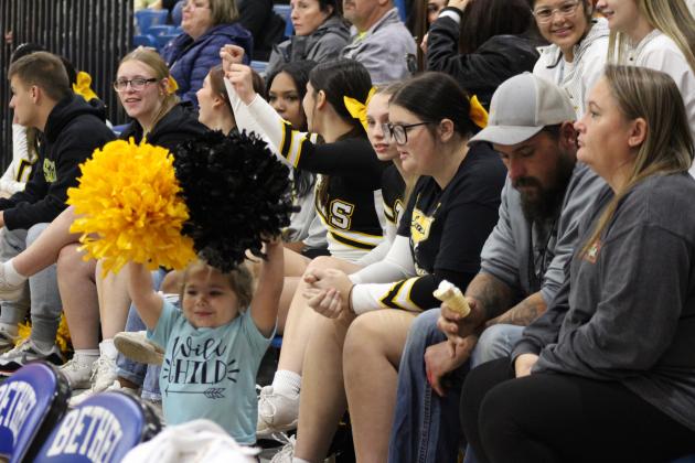 Paislee Hasbell, 2, of Tecumseh, practices cheering, as she watches the Tecumseh High School cheerleaders during the First United Basketball Classic Girls Finals, Dec. 9, at Bethel High School. Countywide &amp; Sun/Natasha Dunagan
