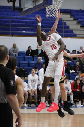 Former Tecumseh Savage and current McLoud Redskin Shaun Hill aims at the bucket and is fouled by Tecumseh's Kohen Warden in the Consolation Round of the First United Basketball Classic, held on Dec. 9 at Bethel High School. McLoud won, 60-39, for the third-place trophy. Countywide &amp; Sun/Natasha Dunagan