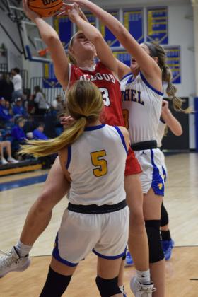 Bethel's Brooklyn Duff stands strong as Mcloud's Creighton Conley shoots for two during the First United Basketball Classic tournament against Bethel last Friday night.  Bethel won, and then lost to Tecumseh in the Championship game the following night.  Countywide/Sun Julie Talton