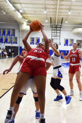 Mcloud's Taycee Lewis shoots off the back of Bethel's Brooklyn Duff during the First United Basketball Classic tournament against Bethel last Friday night.  Bethel won, and then lost to Tecumseh in the Championship game the following night.  Countywide/Sun Julie Talton