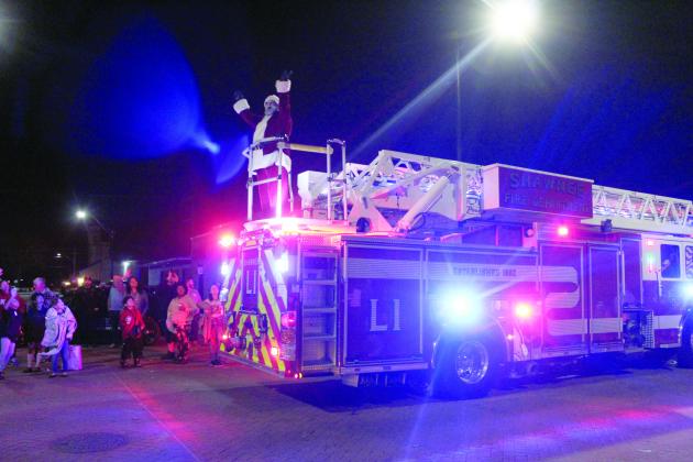 Santa Claus greets children from the back of a fire engine at the end of the Shawnee Christmas Parade on Dec. 8. Countywide &amp; Sun/Natasha Dunagan