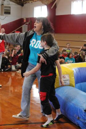 After spinning a wheel and going down an inflatable slide, Judah Hopkins gets a hug from Earlsboro second-grade teacher Stephanie Kleckner before receiving a ROC T-shirt, Jan. 17. Countywide &amp; Sun/Natasha Dunagan