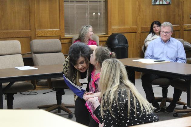 Shawnee pre-schooler Sadie Dobrinski whispers in the ear of SECC Principal Karen Watkins, as Victoria Davenport holds Dobrinski's hand.