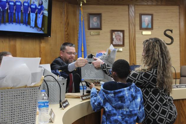 Shawnee Board of Education President Clif Harden accepts gifts from fifth-grader Arlandus Brannon and Horace Mann Elementary Principal Christi Lovelady during the Jan. 8 meeting. January is Board of Education Appreciation Month. Countywide &amp; Sun/Natasha Dunagan
