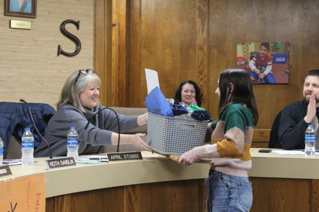 Shawnee Board of Education Clerk April Stobbe accepts a gift basket and wooden sign from Shawnee Middle School student Margot Davidson during the Jan. 8 meeting. January is Board of Education Appreciation Month. Countywide &amp; Sun/Natasha Dunagan