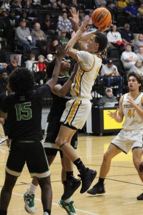 Tecumseh's Aden Boone aims for the basket over two Harding Charter defenders in the second quarter of the Class 4A Distirct game on Feb. 16. The Savages won, 75-74, and will play in Regional competition today (Feb. 22) in Douglass, along with the Lady Savages who also won Districts. Countywide &amp; Sun/Natasha Dunagan