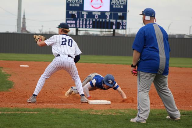 Shawnee freshman Rhett Hokit waits for the catch as a Harrah runner dives back to first base during the home game on March 22. Harrah won both games in the double header, 8-0 and 3-1. Countywide &amp; Sun/Natasha Dunagan